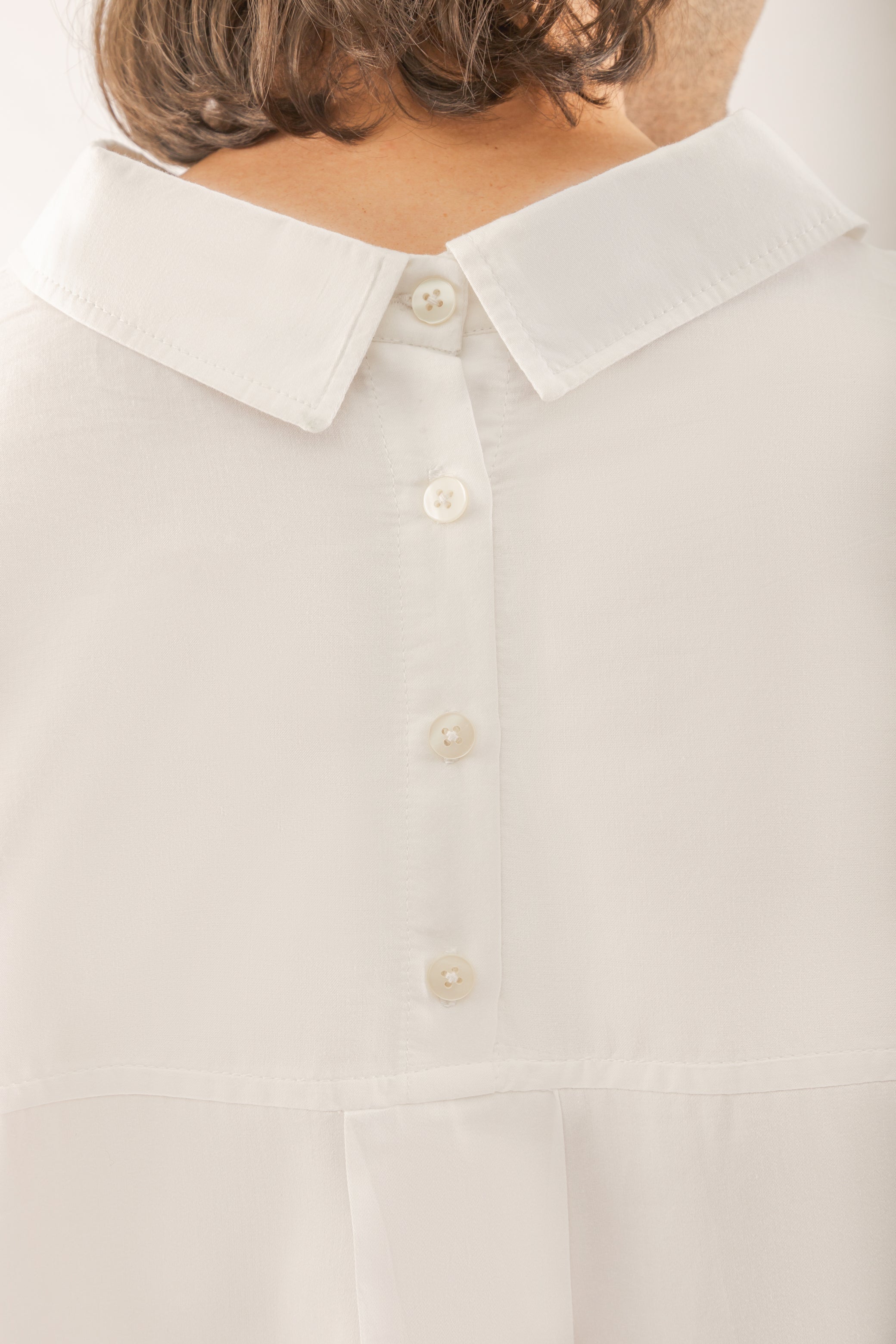 camisa blanca con botones en la espalda